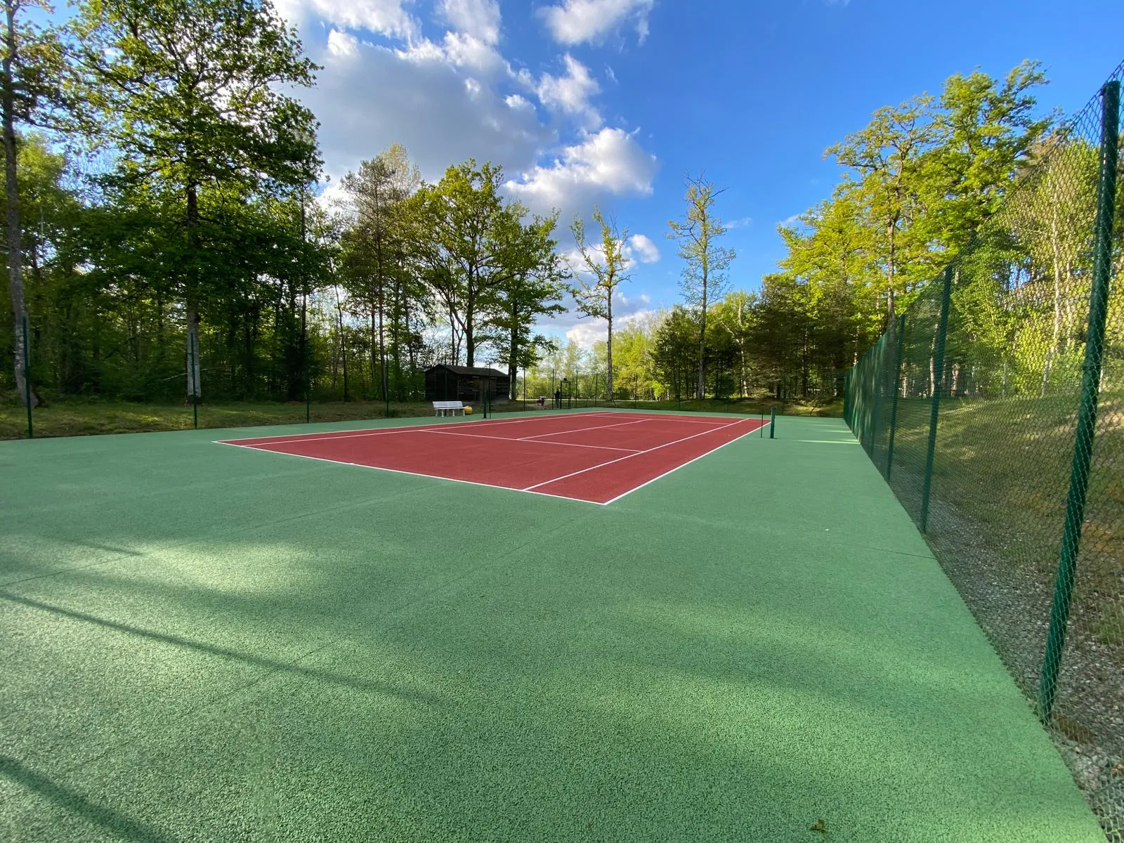 Resurfaçage d’un court de tennis en béton poreux avec application d’un nouveau revêtement suivant des procédés innovants.