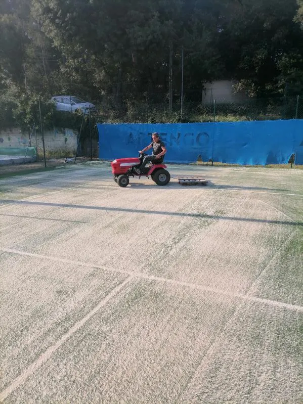 Opération de brossage et redressage des fibres sur gazon synthétique de tennis
