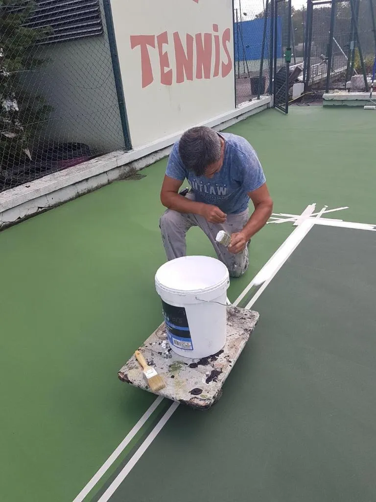 Peinture des lignes après rénovation d’un terrain de tennis en résine acrylique