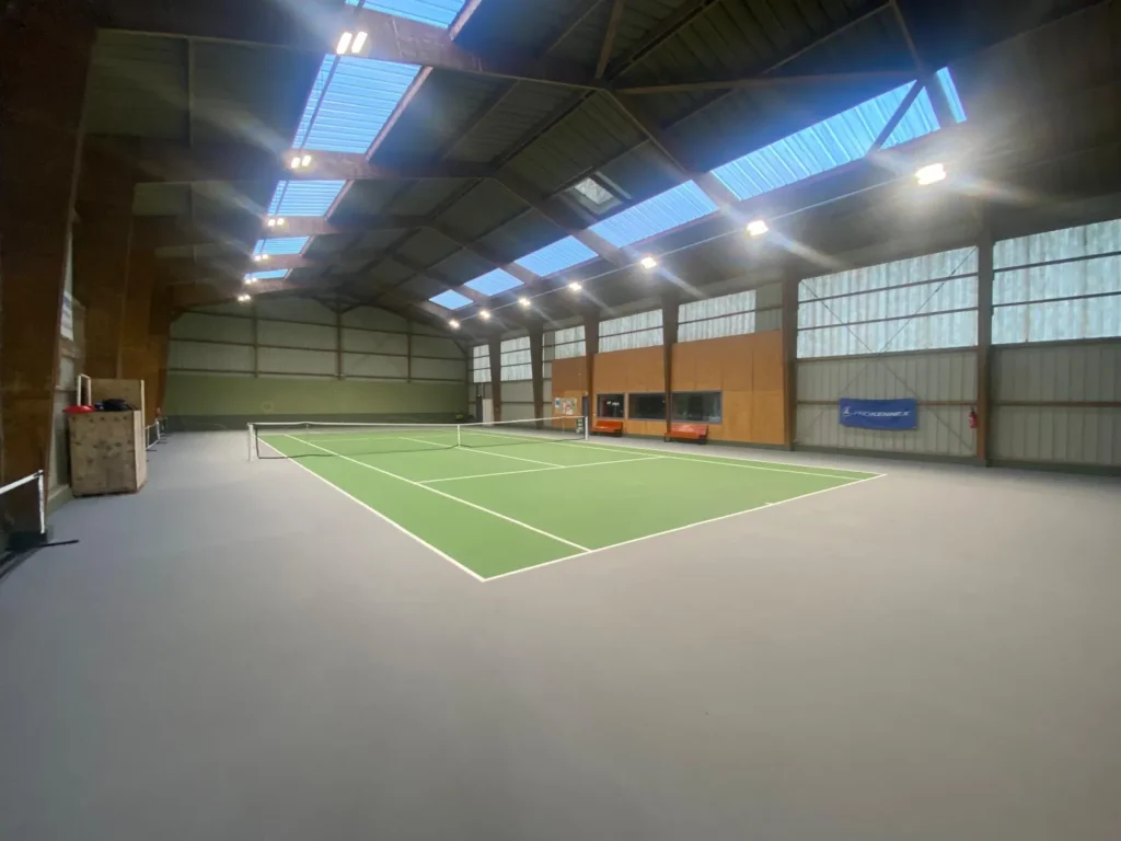 Court de tennis intérieur rénové avec résine synthétique multicouche