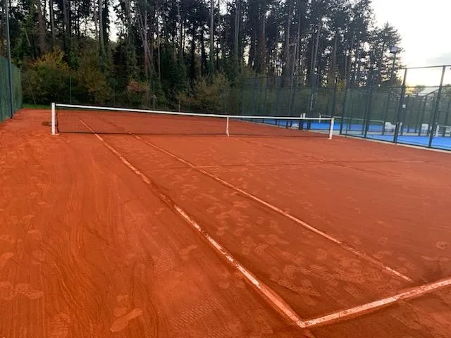 Court de tennis rénové avec une moquette aiguilletée imitation terre battue